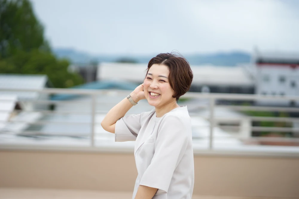 屋外で自然な笑顔を見せる女性のポートレート
